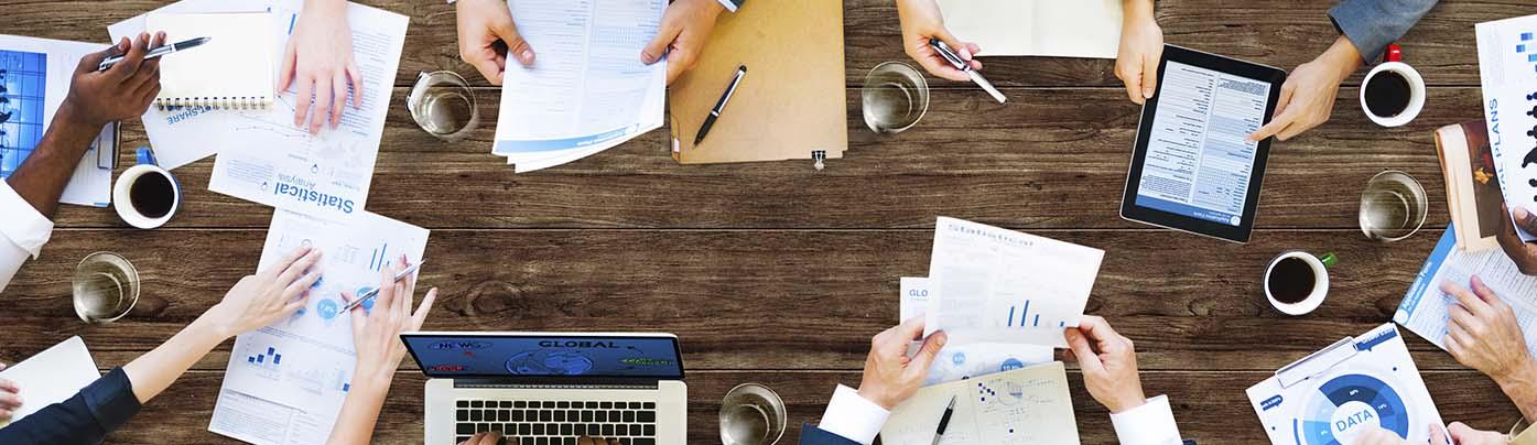 Bild på ett konferensbord med människor som arbetar. Foto: Adobe Stock Images