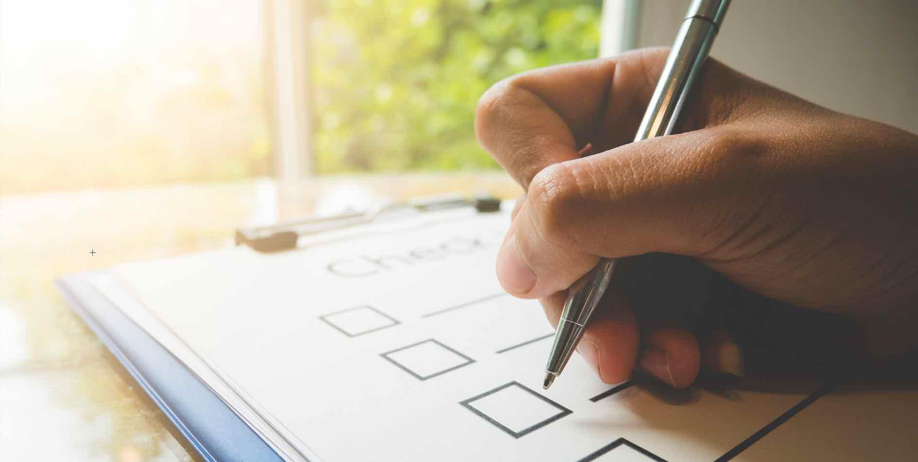 Hand som skriver på checklista.