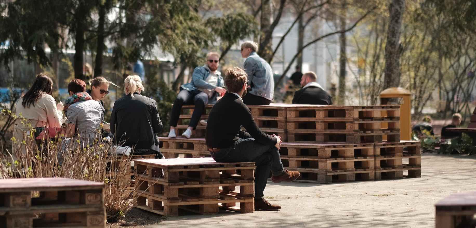 Människor sitter på lastpallar i Grönlandsparken.