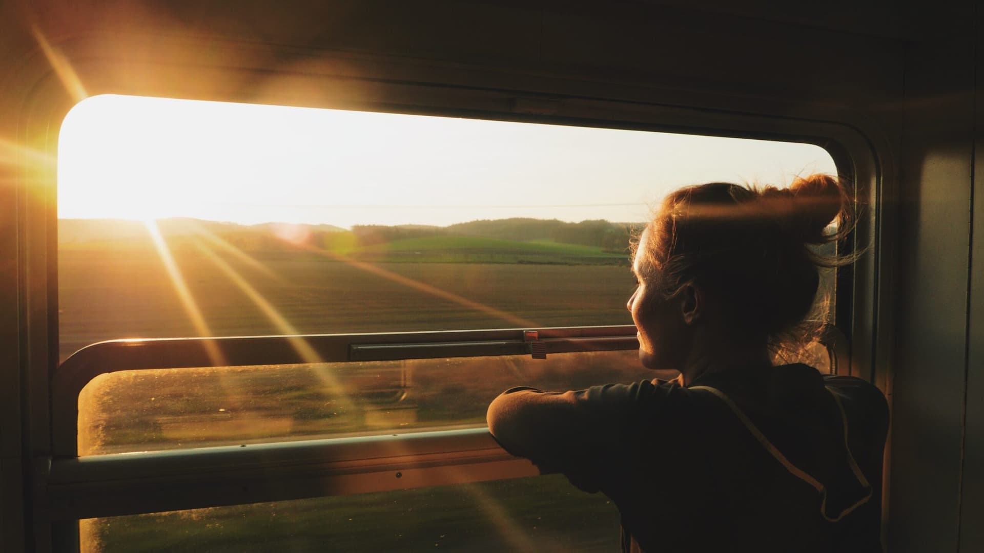 Kvinna ser ut genom ett tågfönster.