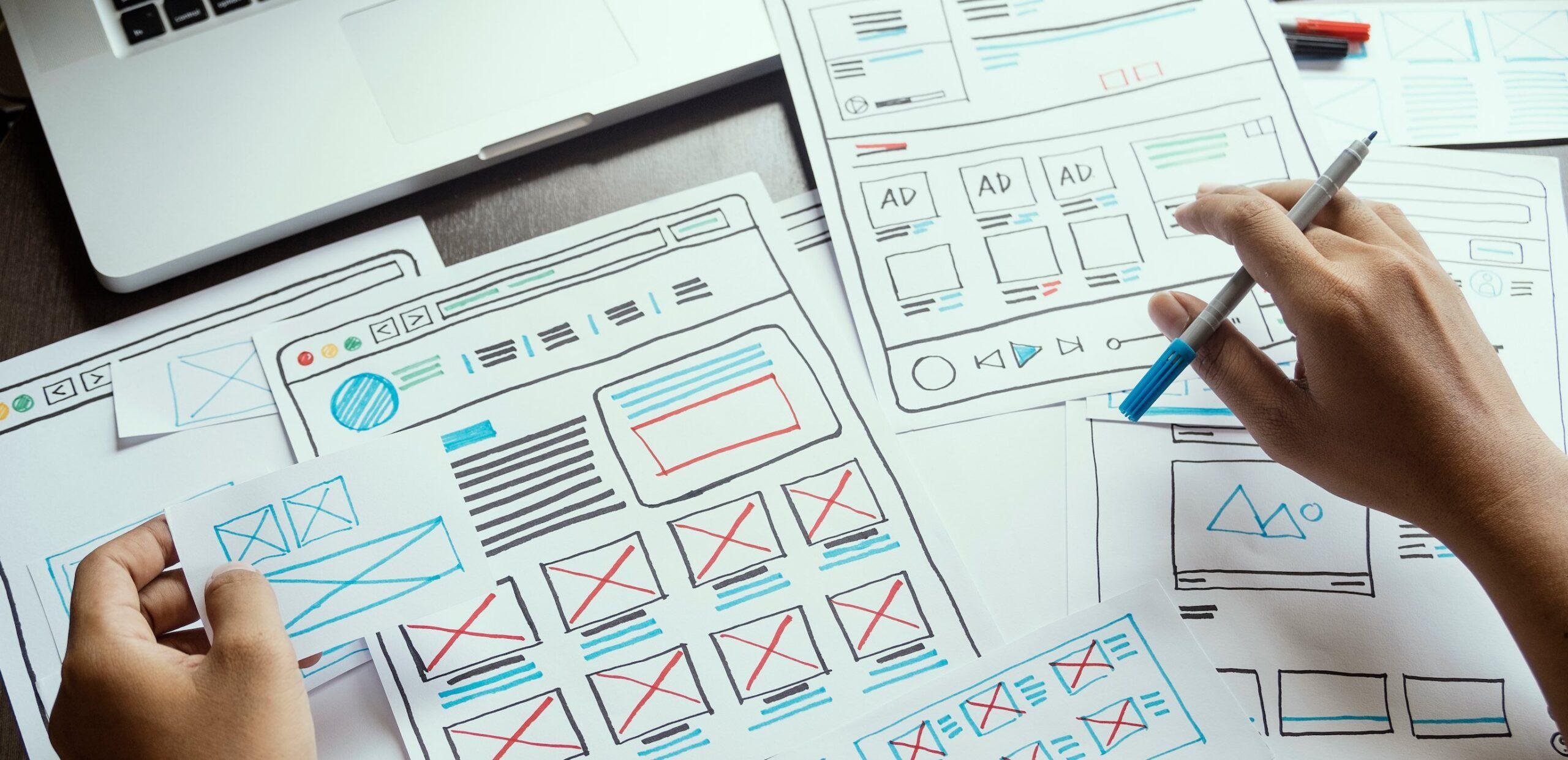 Bild på händer som skissar upp en ny hemsida.