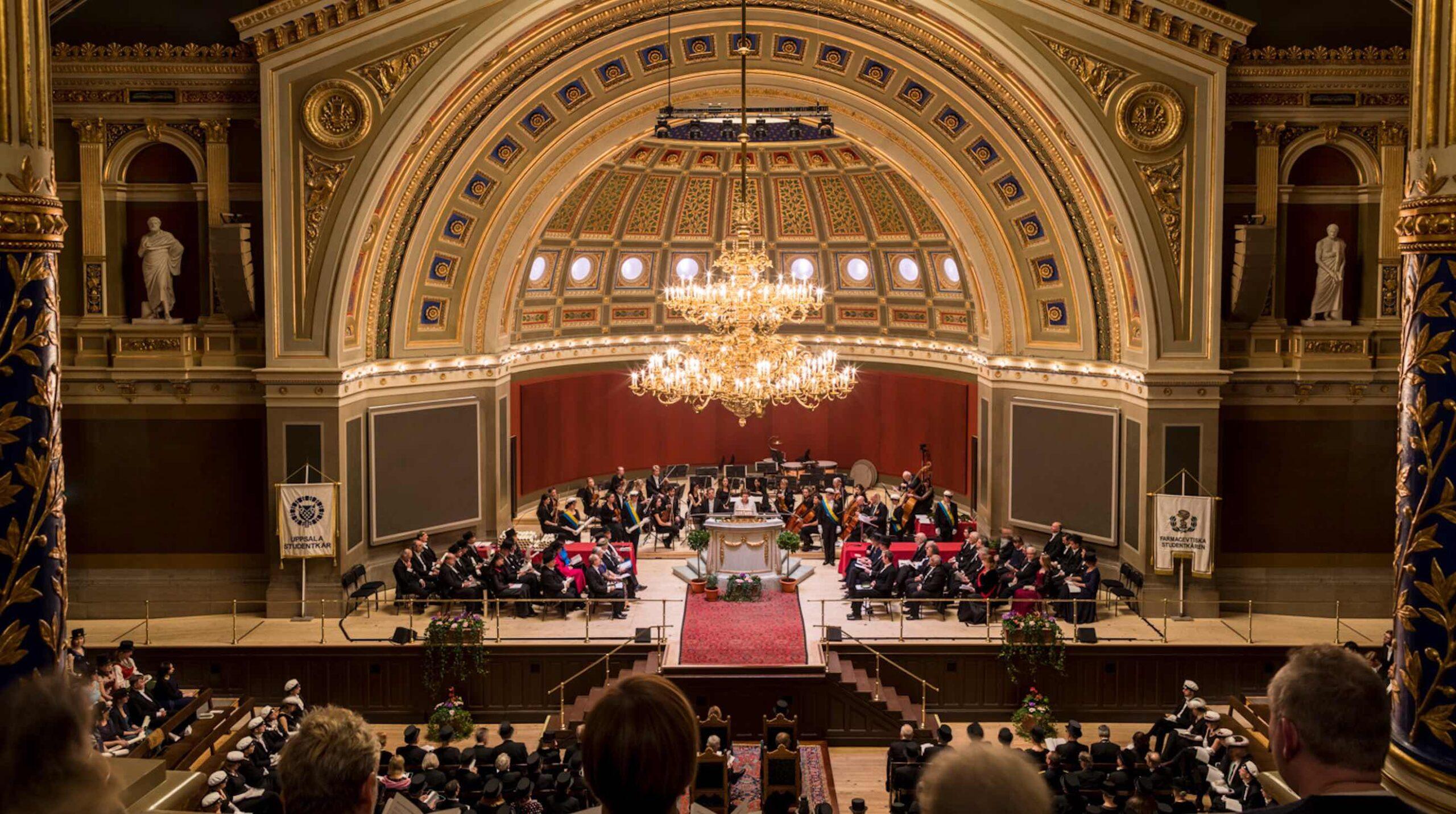 Bild på universitetsaulan i Uppsala med publik.